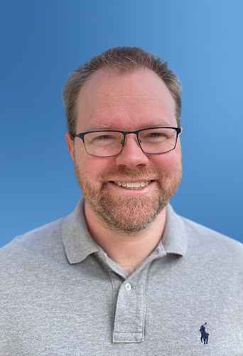 Man with glasses smiling against a blue background, showcasing legal ai software.