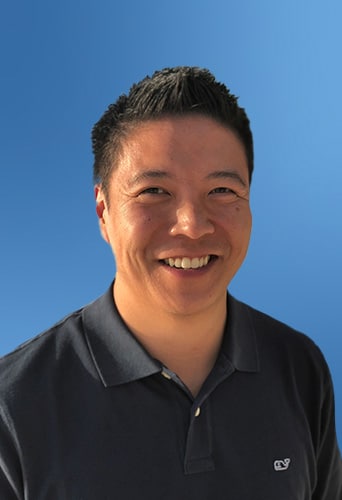 A smiling man with short hair, possibly evaluating legal AI software, against a blue background.